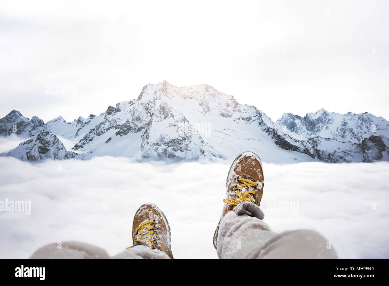 Viaggiatore seduto sul picco di montagna, POV vista sulla grande montagne  invernali al di sopra del