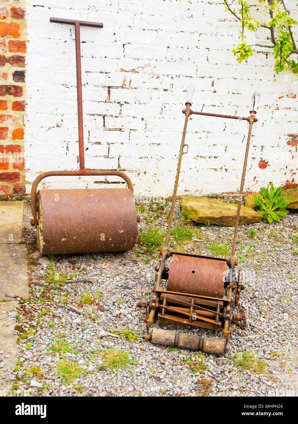 Vecchie macchine da giardinaggio tosaerba e rullo di Rusty e trascurato all'heritage walled garden a Preston Park Museum Foto Stock