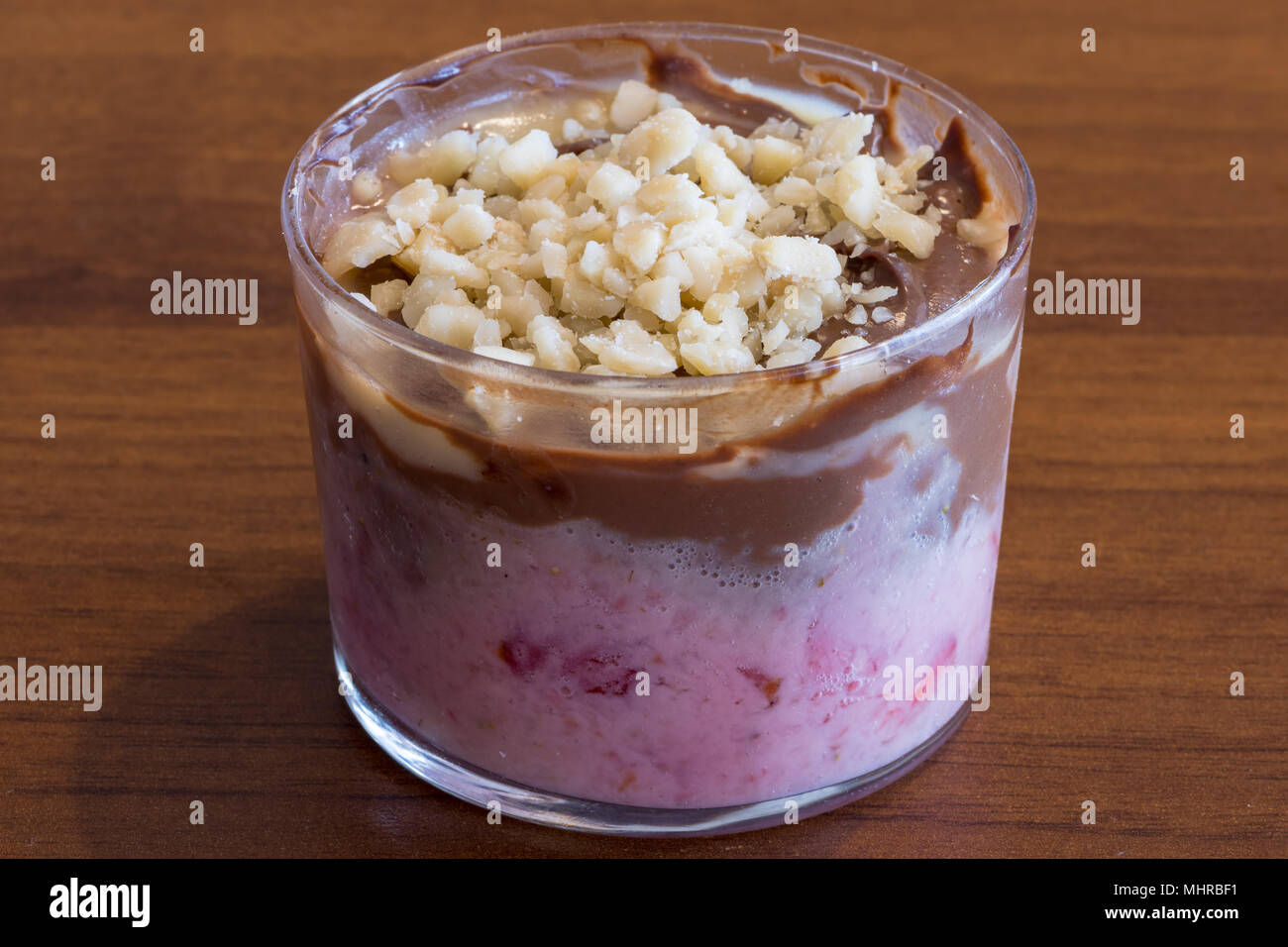 Dolce cucchiaio con fragola e crema di cioccolato, dessert in vetro trasparente. Fotografia di cibo Foto Stock