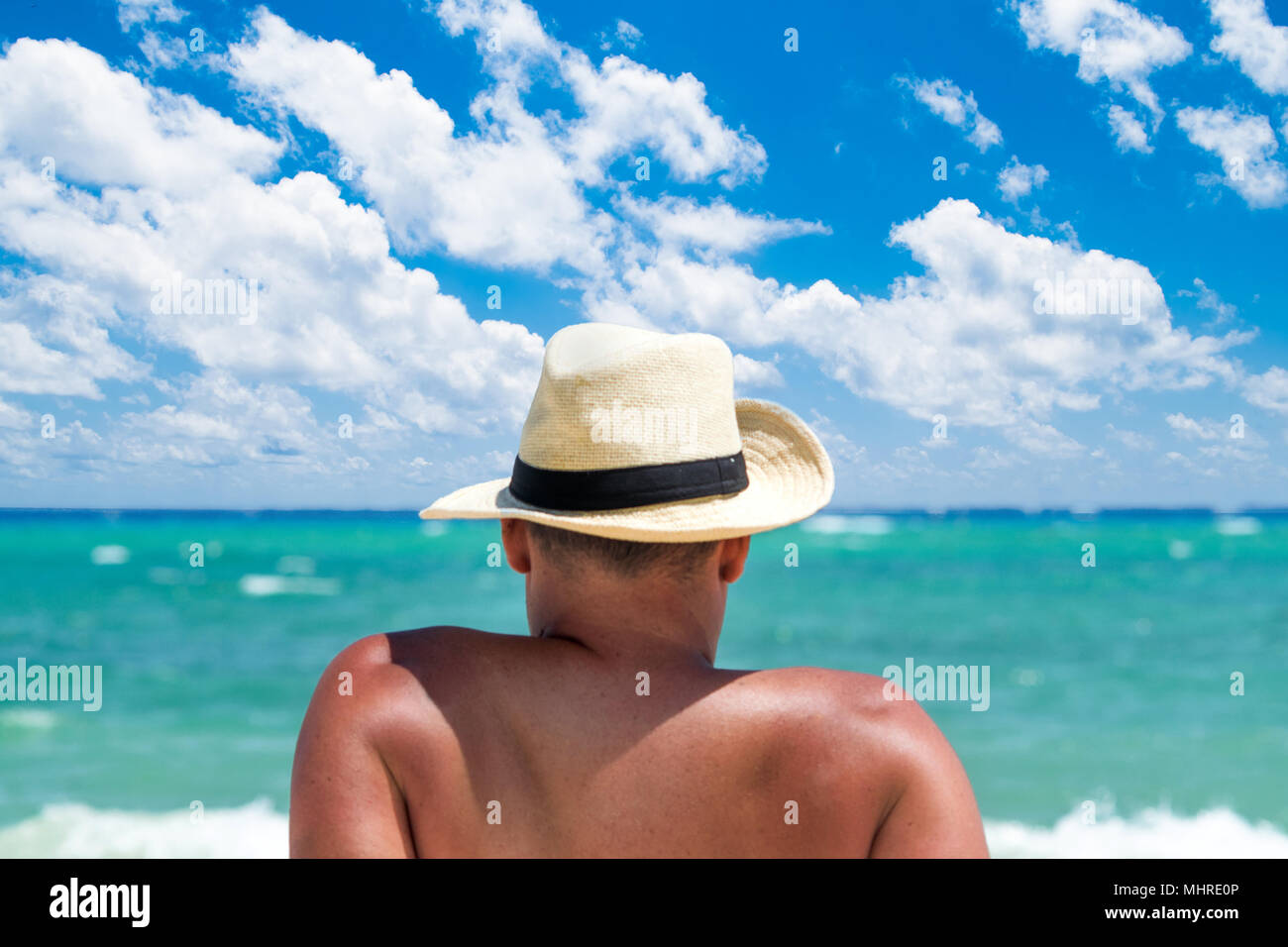 Vista posteriore di un uomo con il cappello di relax presso la spiaggia tropicale Foto Stock