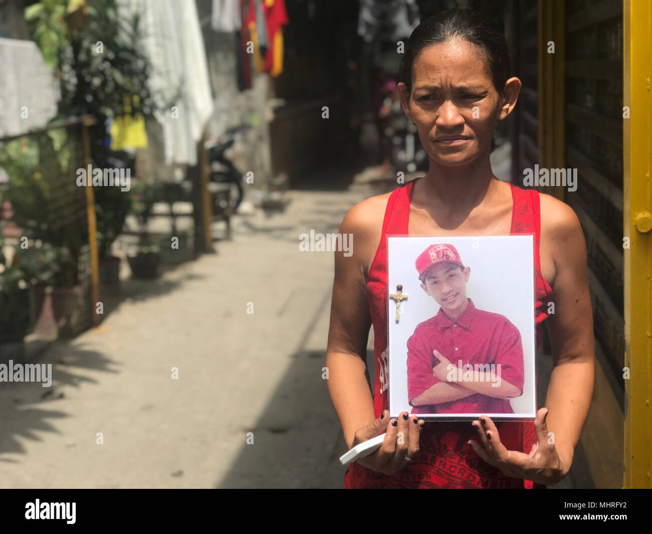 19 aprile 2018, Filippine, Manila: il filippino Maria Victoria Dahohoy mostra una foto di suo figlio che è stato girato in Bagong Silang, un sobborgo della capitale Manila. Quindici anni è uno delle migliaia di vittime del anti-droga guerra condotta dal presidente Rodrigo Duterte. Foto: Christoph Sator/dpa Foto Stock