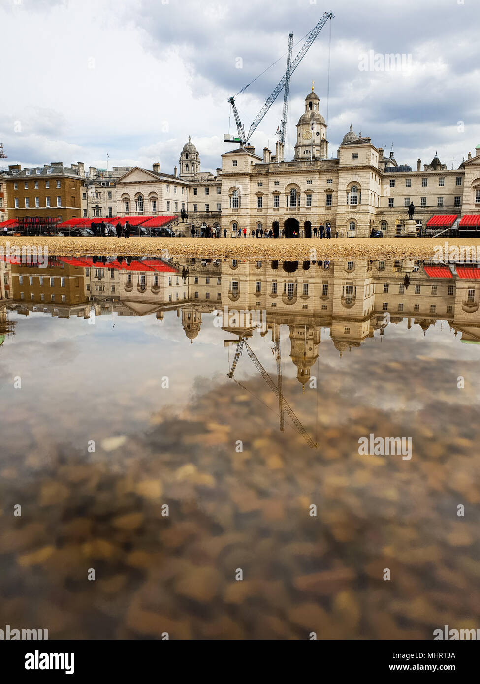 Londra. Regno Unito 3 Maggio 2018 - La riflessione di edifici governativi e costruire gru in una giornata di sole in una pozza d'acqua in Horse Guards causato dalla recente pioggia pesante Credito: Roamwithrakhee/Alamy Live News Foto Stock