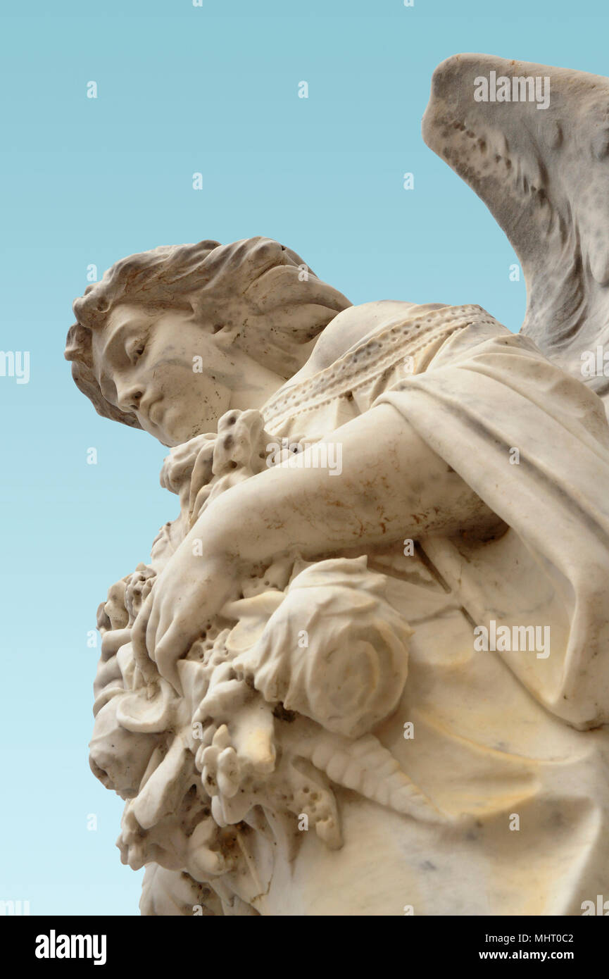 Una statua di un angelo guarda verso il basso come se a custodire e proteggere. Foto Stock