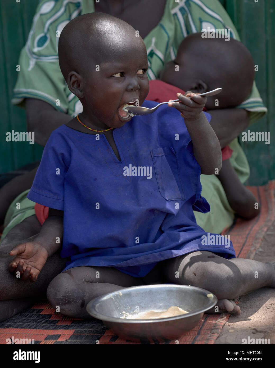 Un bambino mangia in caso di emergenza programma alimentare per i bambini malnutriti a Loreto ragazze School di Rumbek, nel sud Sudan. Foto Stock