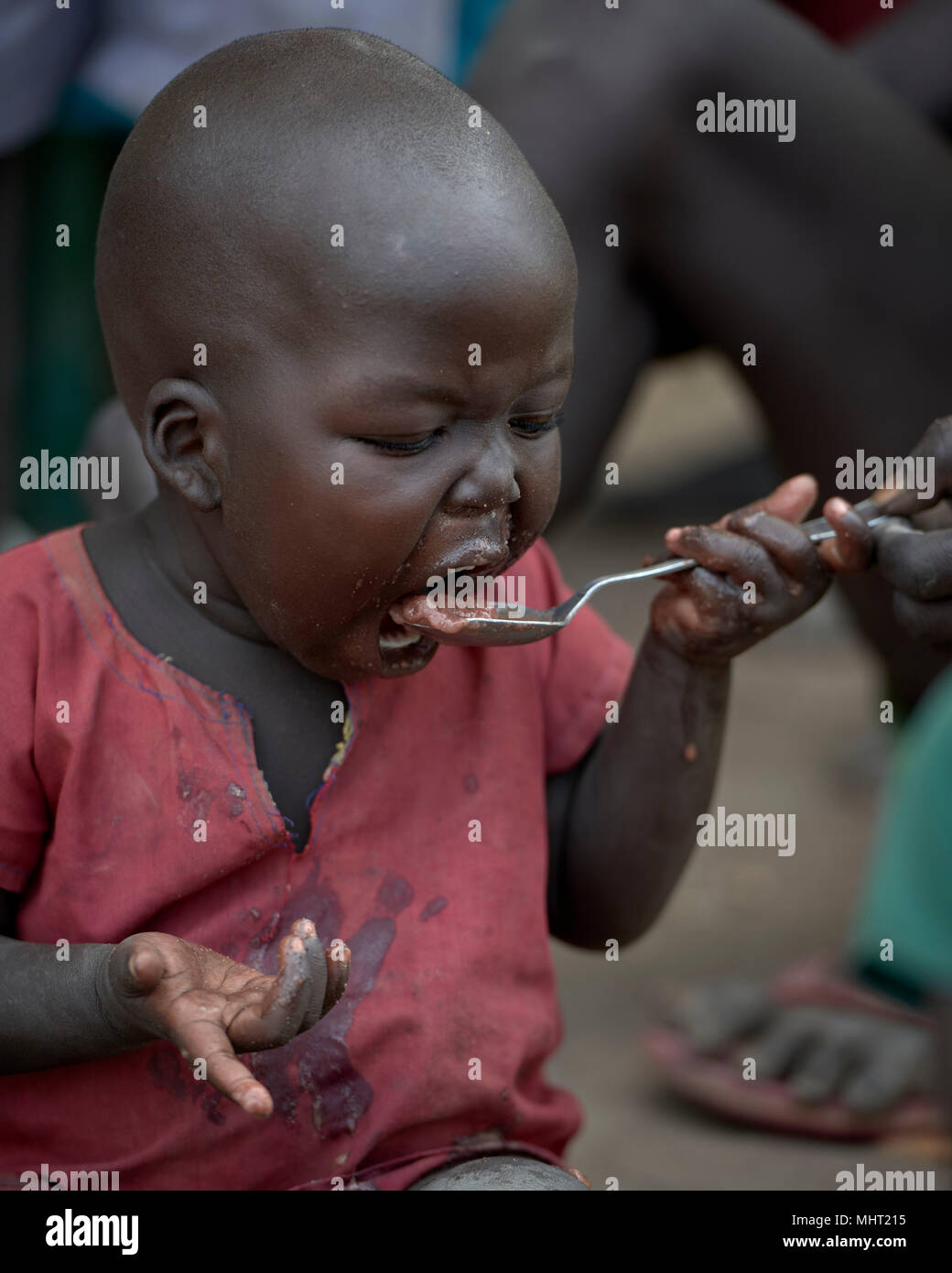 Un bambino mangia in caso di emergenza programma alimentare per i bambini malnutriti a Loreto ragazze School di Rumbek, nel sud Sudan. Foto Stock