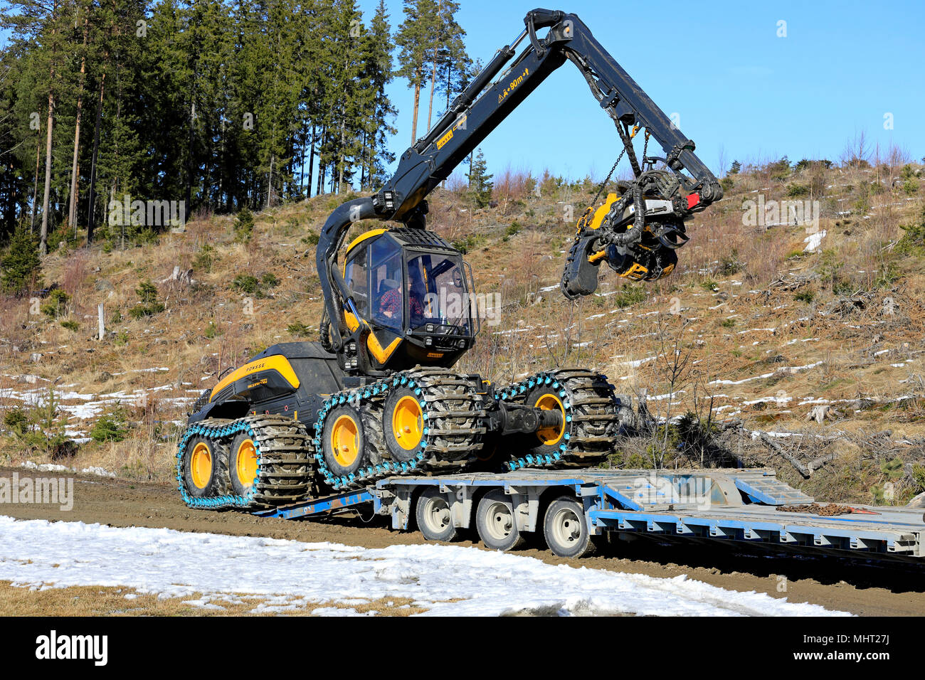 Macchina forestale operatore guida Ponsse Scorpion re harvester sul rimorchio di trasporto in una giornata di sole di primavera a Salo, Finlandia - 31 Marzo 2018. Foto Stock