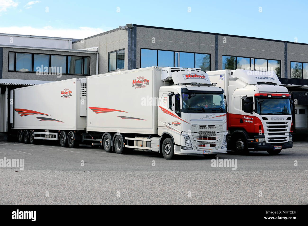 FH Volvo e Scania refrigerati camion rimorchio scarico presso warehause zona di carico su un chiaro pomeriggio estivo a Salo, Finlandia - 21 luglio 2017. Foto Stock