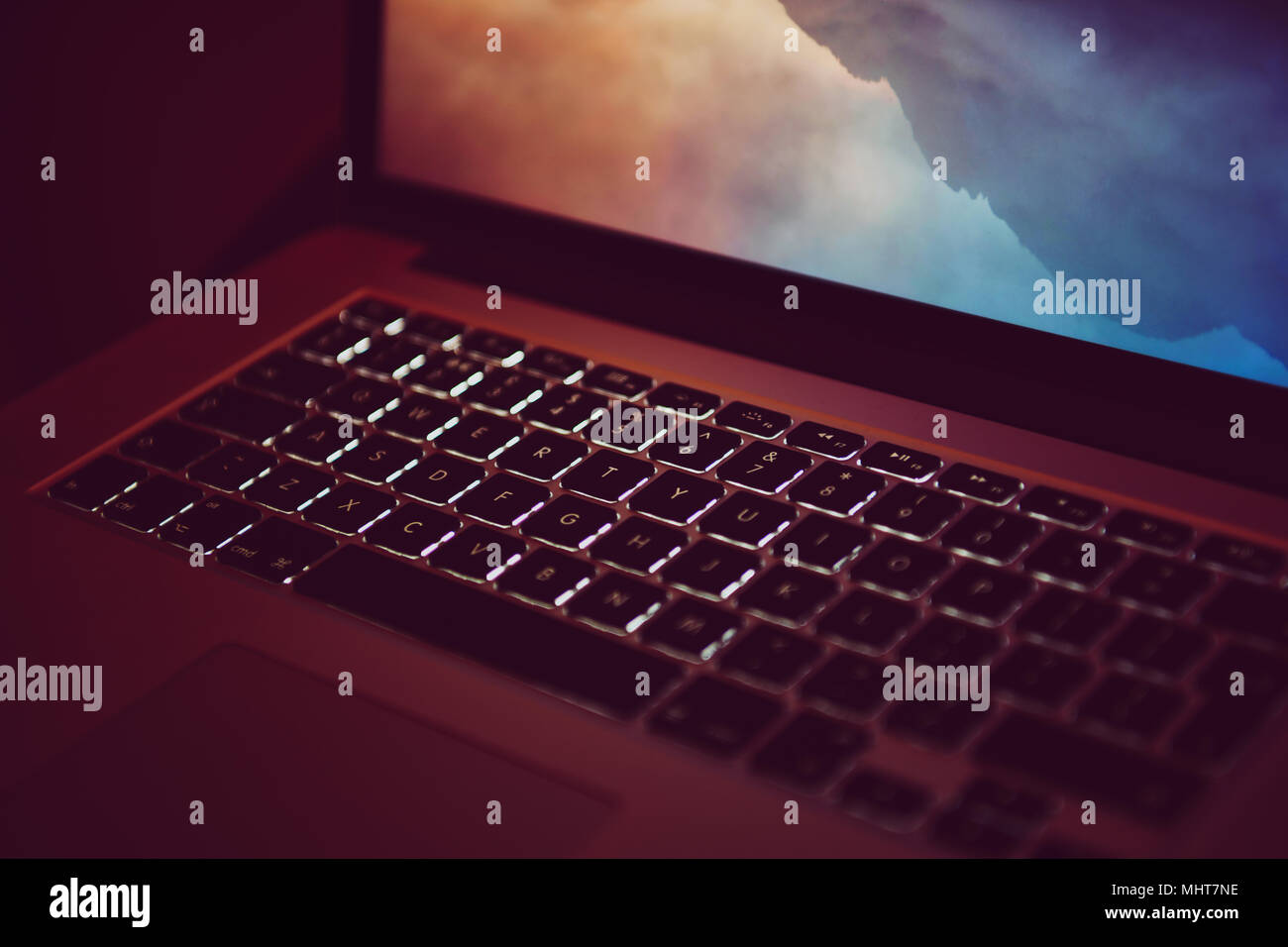 Lo schermo del notebook e la tastiera incandescente in un design studio Foto Stock