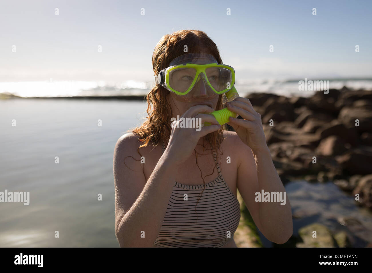 Donna che indossa la maschera di snorkelling vicino al mare Foto Stock