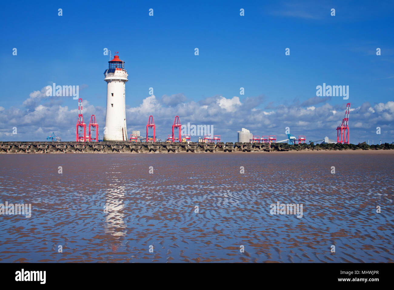 Pesce persico Rock Lighthouse, guardando al di là del mare difese di New Brighton, con la sorprendente gru rossa di Liverpool docks in background Foto Stock