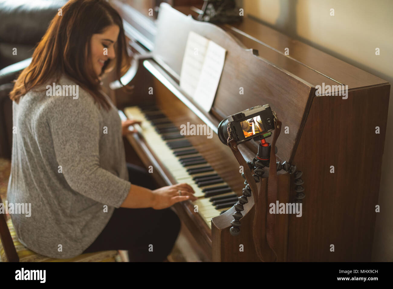 Bellissima femmina vlogger suonando piano Foto Stock