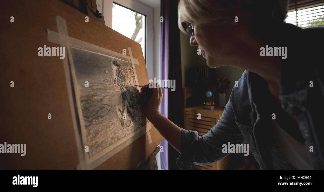Donna matura artista pittura foto a casa Foto Stock
