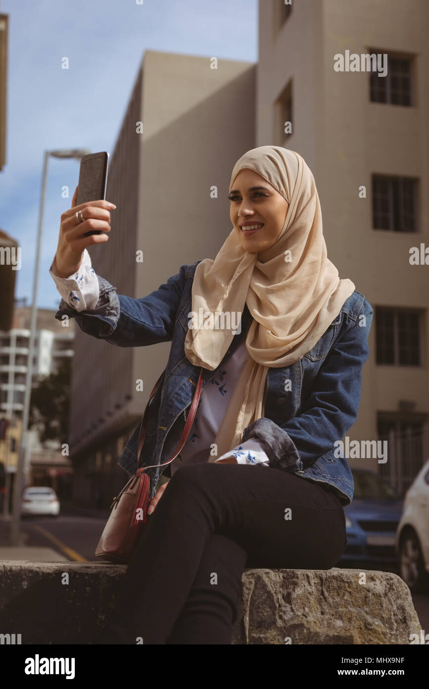 Urban hijab donna prendendo selfie con telefono mobile Foto Stock
