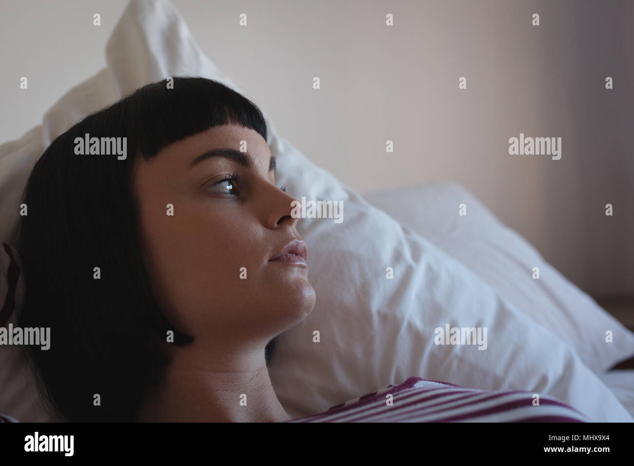 Preoccupato donna rilassante in camera da letto Foto Stock