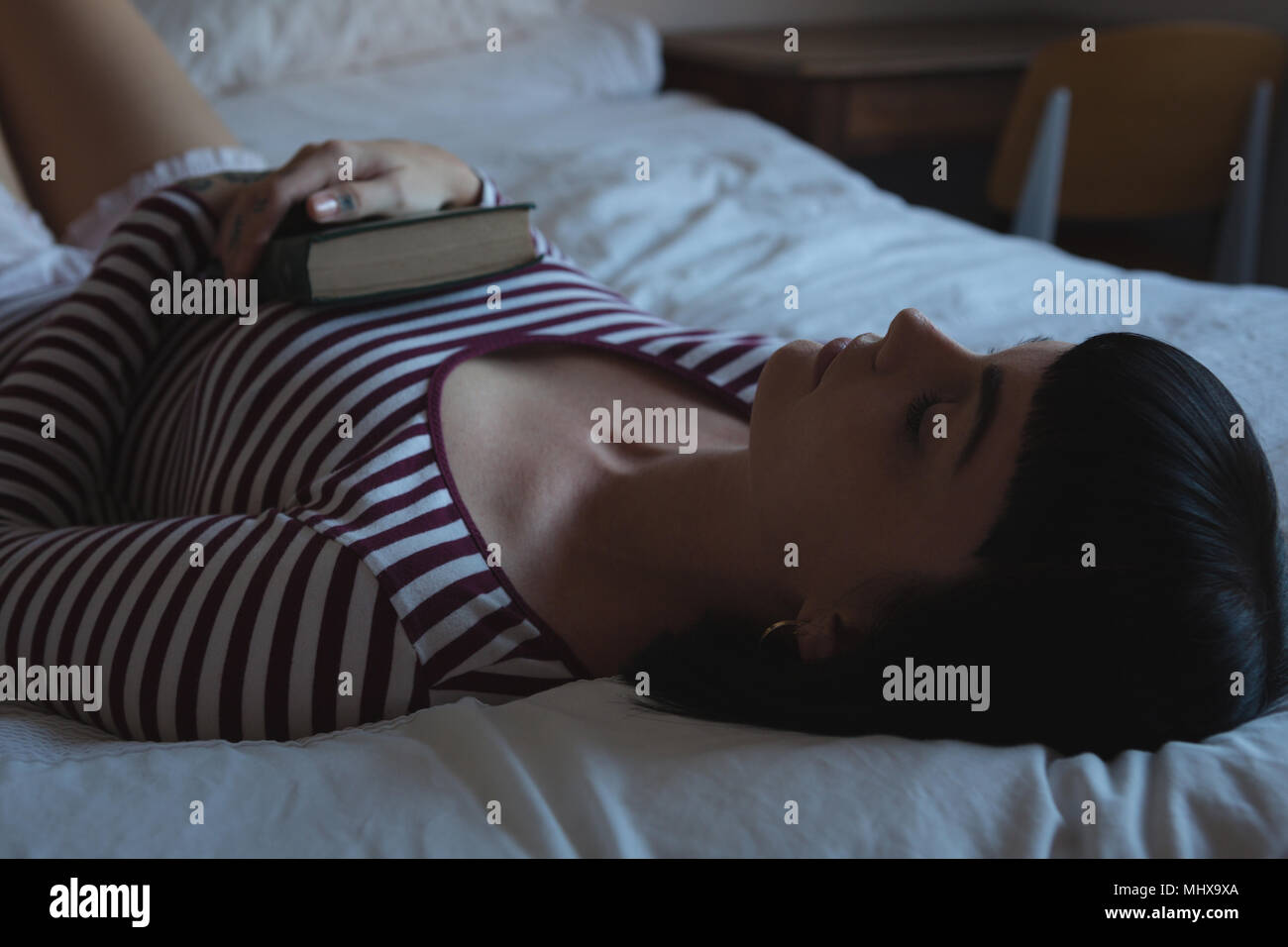 Donna che dorme nella camera da letto di casa Foto Stock