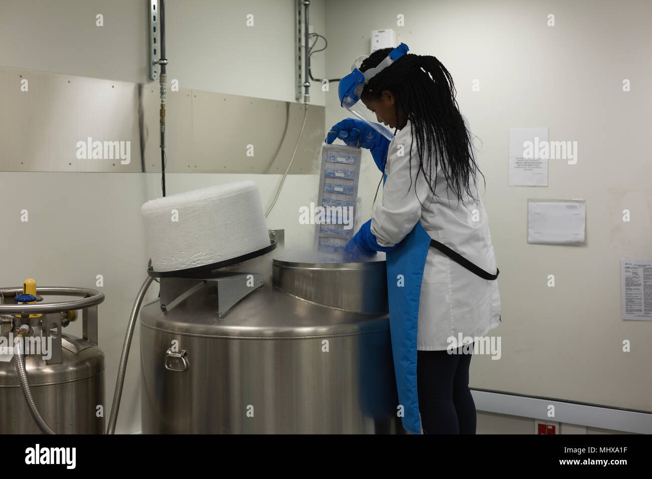 Donna scienziato rimuovendo i campioni di medicinali dalla macchina Foto Stock