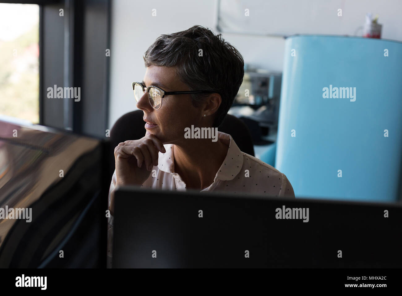 Imprenditrice maturo che guarda lontano in ufficio Foto Stock