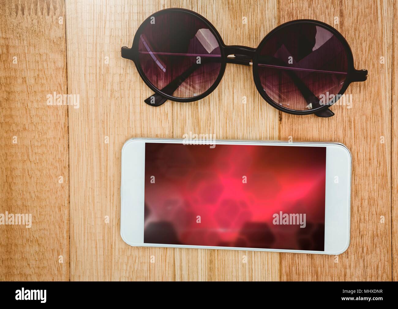 Telefono con gradiente rosso e occhiali da sole Foto Stock
