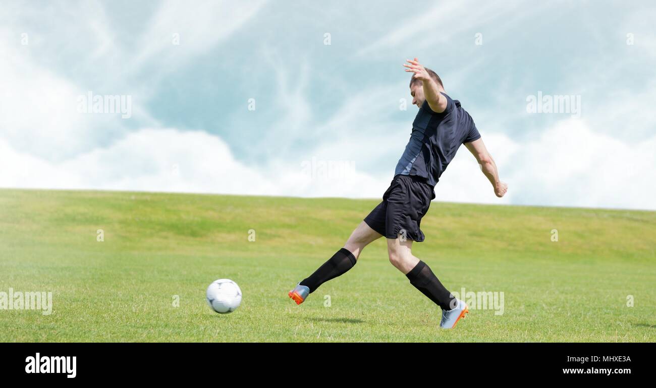 Giocatore di calcio calci calcio in erba Foto Stock