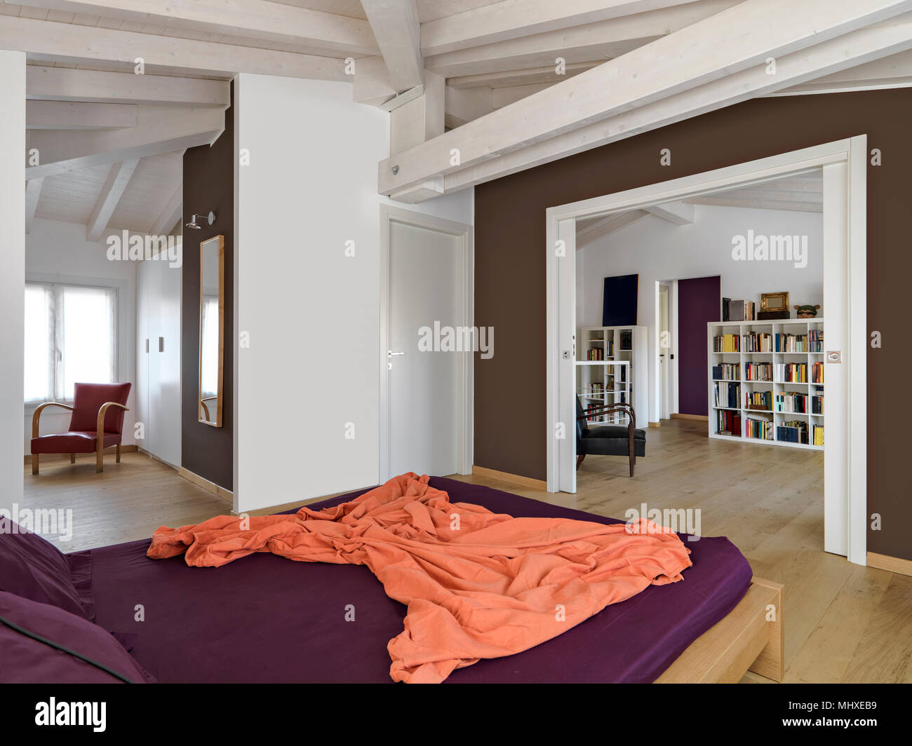 Scatti di interni di una moderna camera da letto in mansarda camera con guardaroba e pavimento in legno Foto Stock