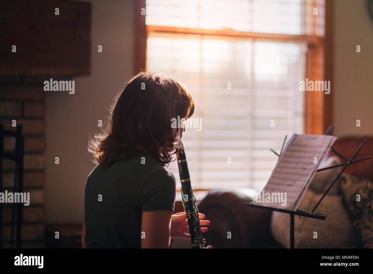 Ragazza al clarinetto pratica da finestra Foto Stock