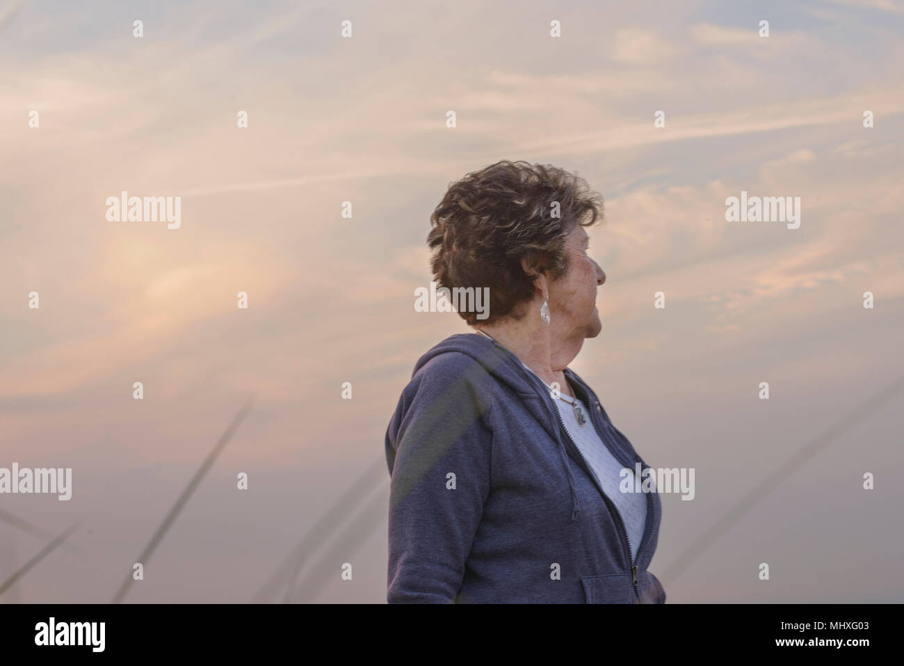 Donna con la faccia rivolta in allontanamento, sky in background Foto Stock