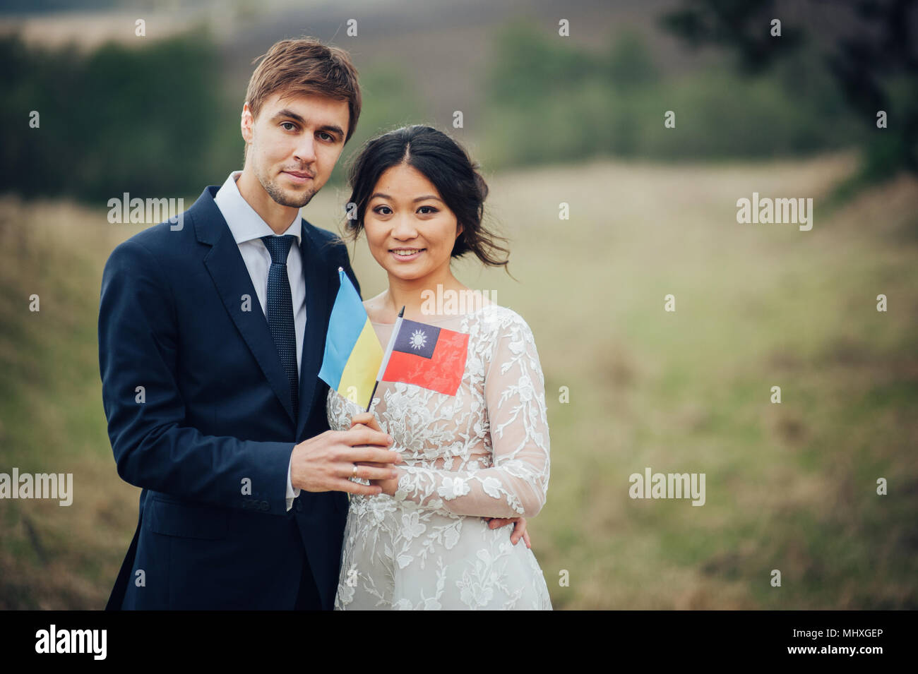 Lo sposo e la sposa tenendo le bandiere di Ucraina e Taiwan Foto Stock