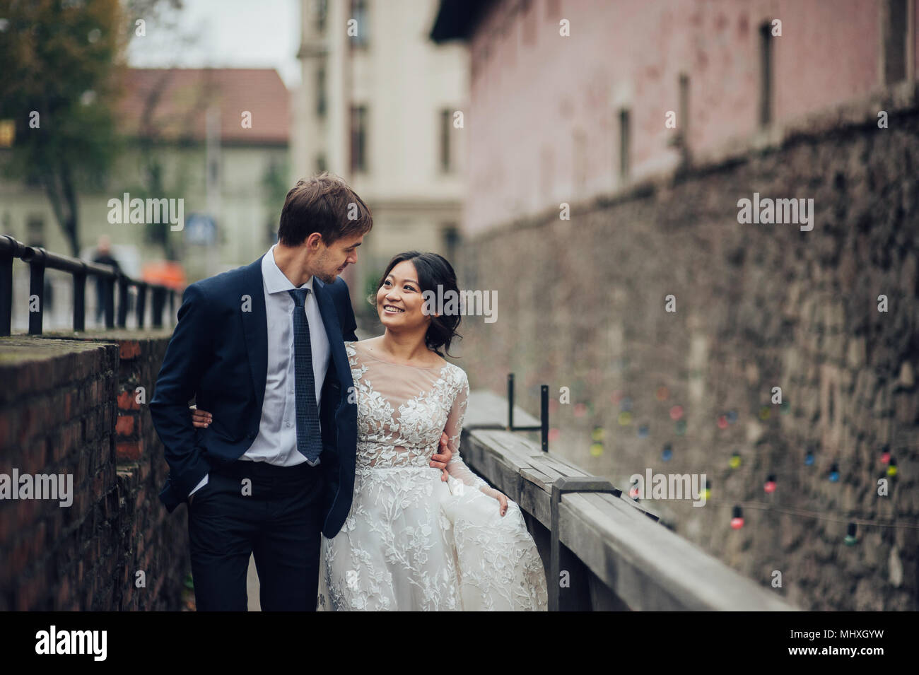 Lo sposo con la sposa a piedi nella città vecchia cantieri Foto Stock