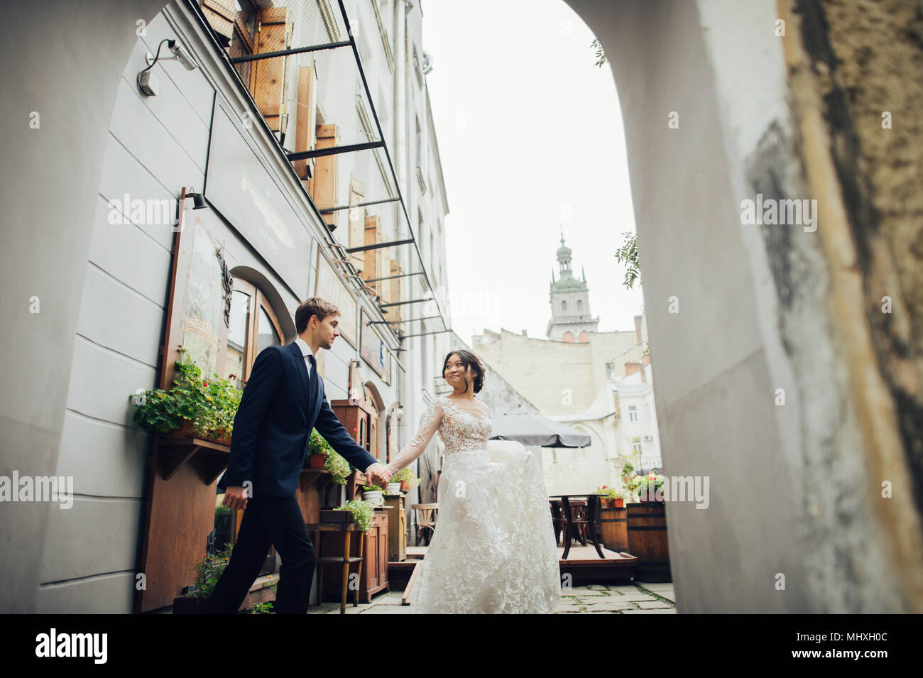 Lo sposo con la sposa a piedi nella città vecchia cantieri Foto Stock