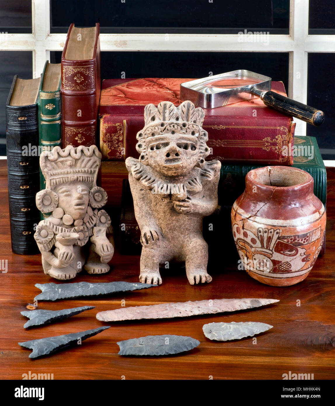 Antique pre colombiana collezione sul tavolo con libri antichi. Foto Stock