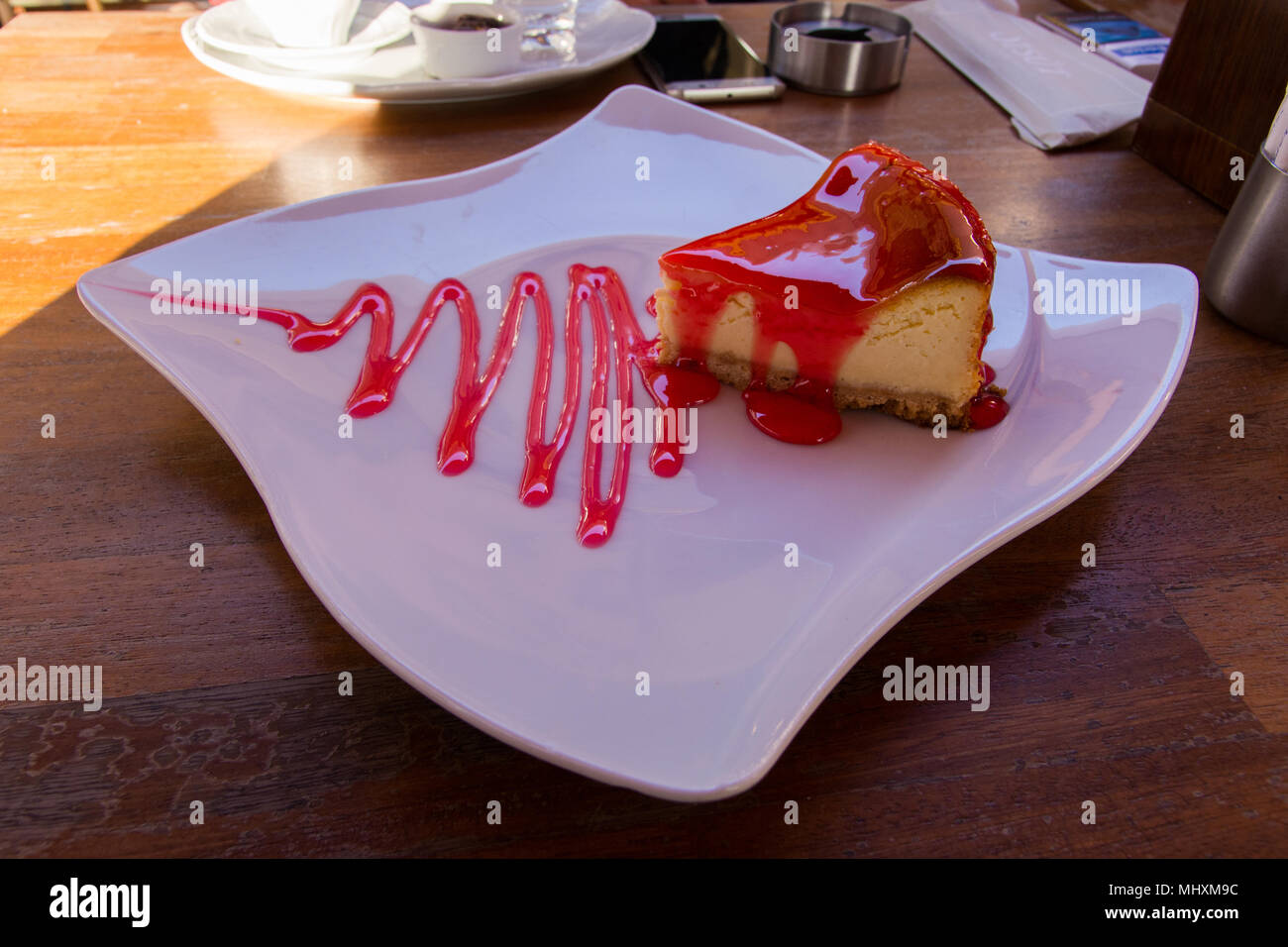 Strawberry Cheesecake. una fragola crema torta con salsa di fragole servite su un piatto di nizza Foto Stock