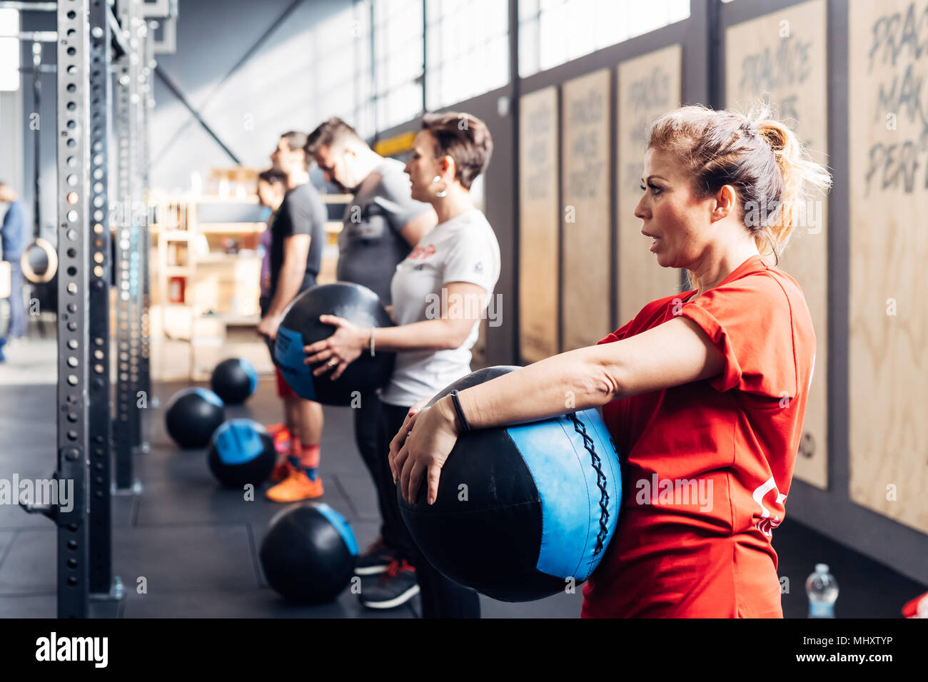 Un gruppo di persone in palestra utilizzando sfere di medicina Foto Stock