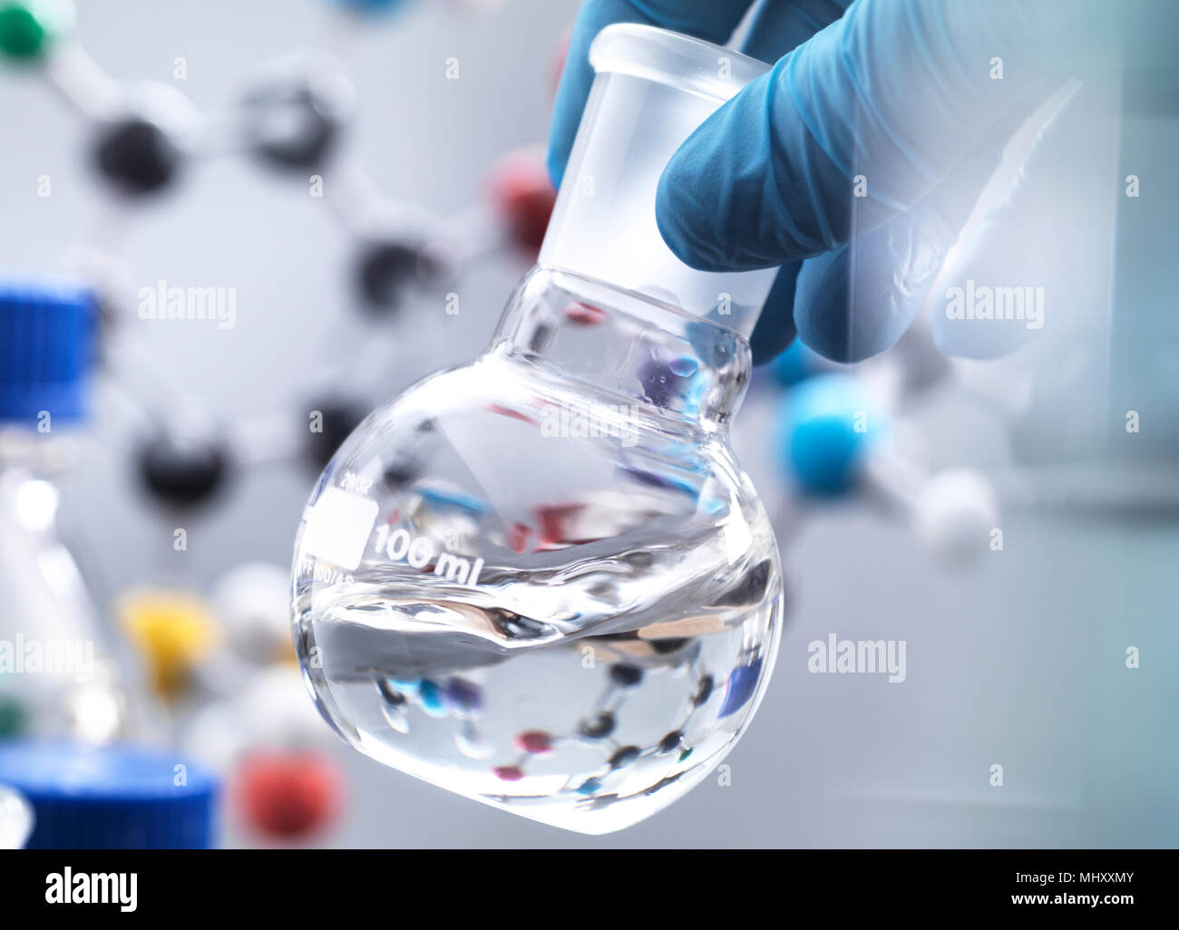 Scienziato preparazione di formula chimica in un pallone da laboratorio durante un esperimento, modello molecolare in background Foto Stock