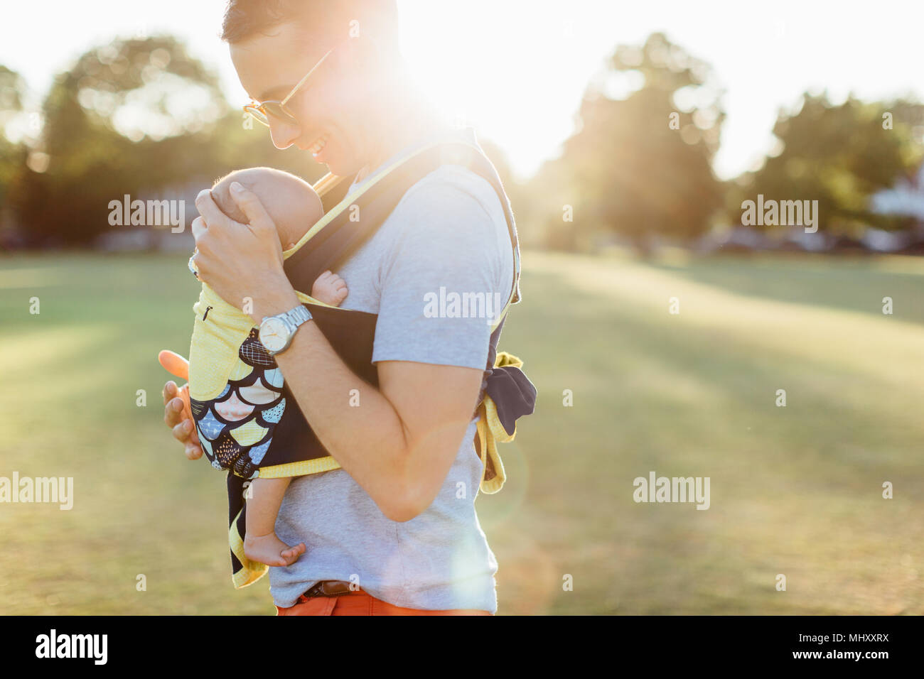 Padre che trasportano baby boy in baby carrier Foto Stock