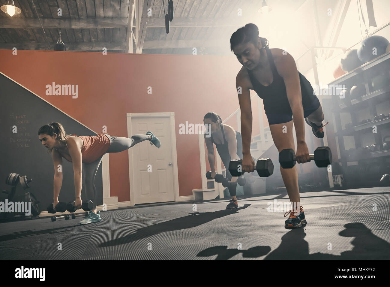 Il gruppo di donne in palestra esercizio utilizzando manubri Foto Stock