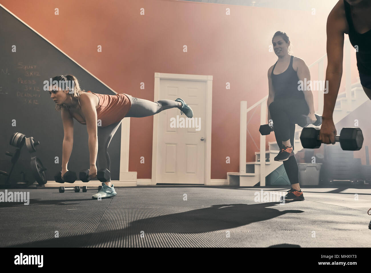 Il gruppo di donne in palestra esercizio utilizzando manubri Foto Stock