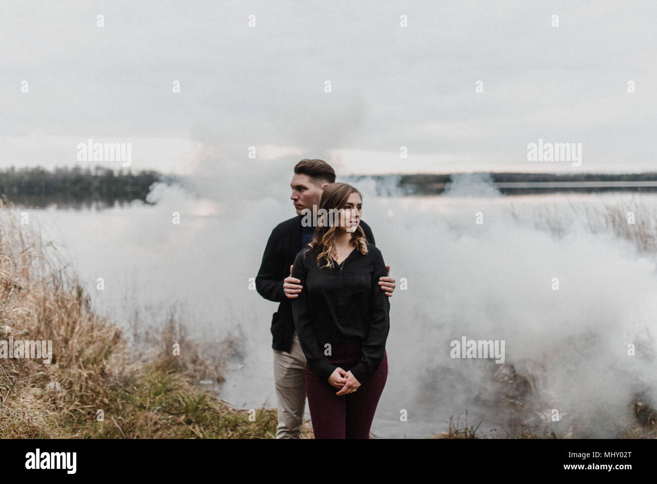 Coppia giovane dalla nuvola di fumo che guarda lontano, Ottawa, Canada Foto Stock