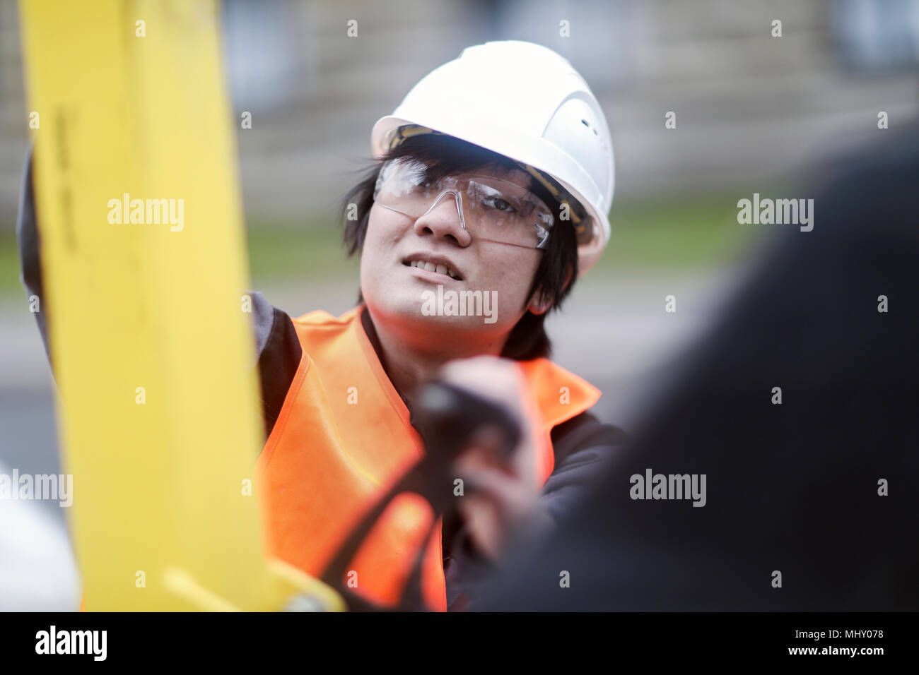 Giovane lavoratore edile indossare elmetto Foto Stock