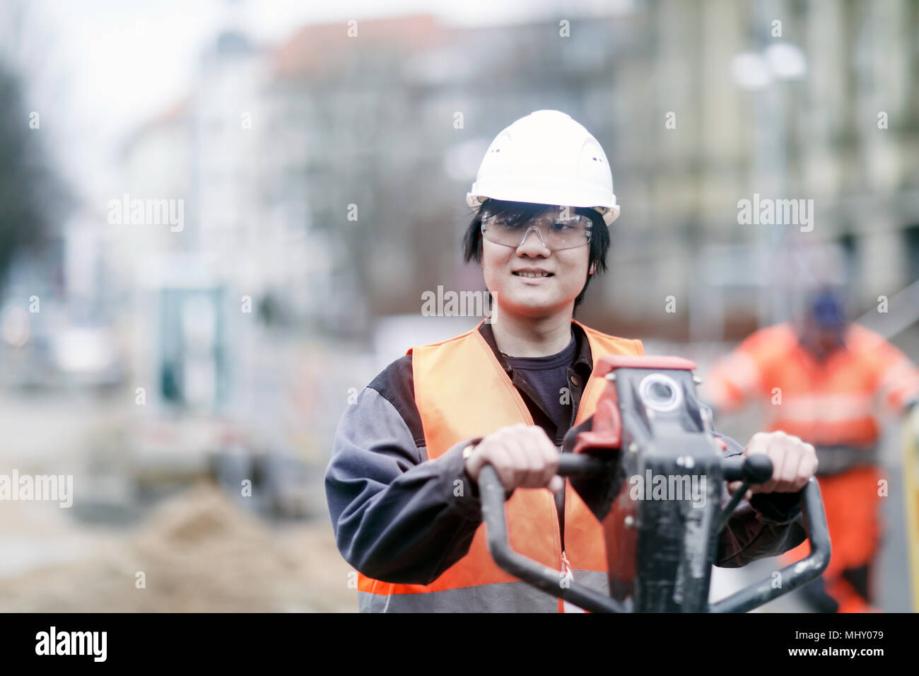 Giovane lavoratore edile indossare elmetto Foto Stock