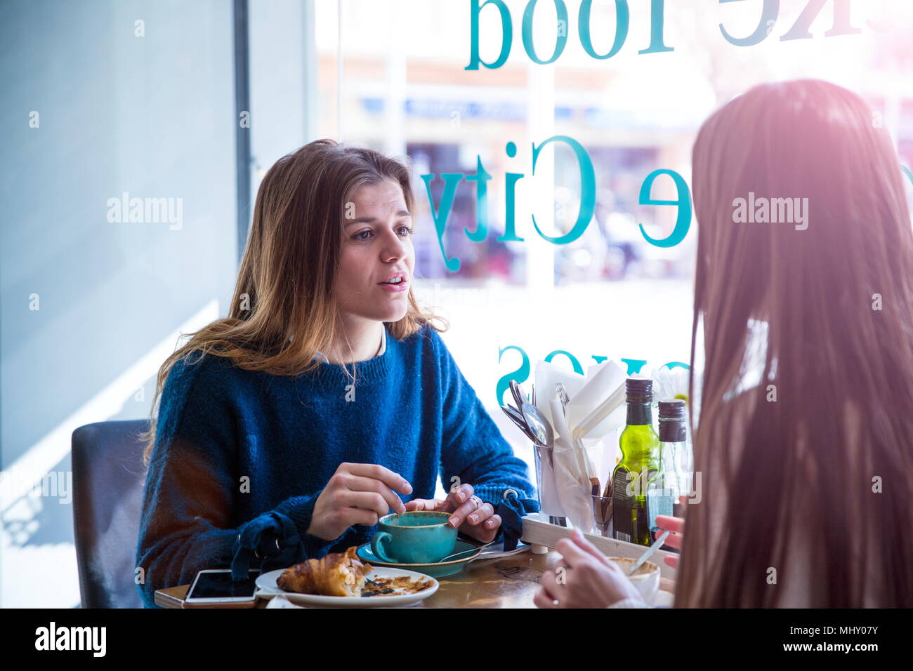 Due amiche seduti insieme in cafe, bere caffè Foto Stock