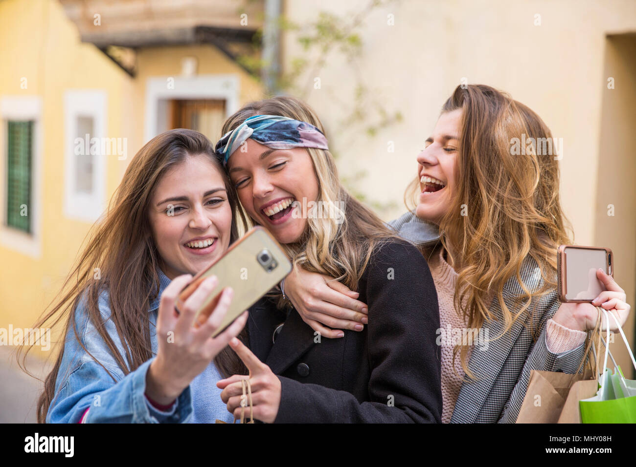 Amici prendendo selfie in strada Foto Stock