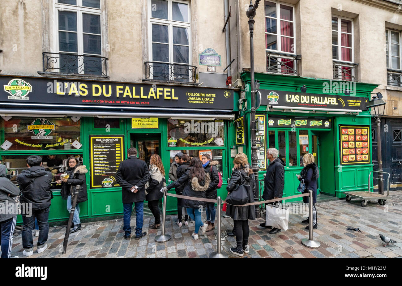La gente in coda fuori l'Come du Fallafel molto popolare di Kosher ristorante Medio Orientale Situato a 34, rue des Rosiers , paris , France Foto Stock