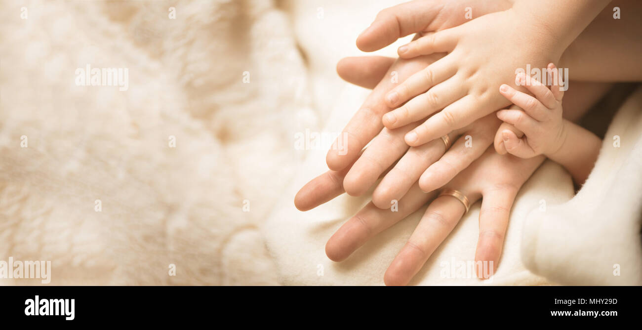 Bambino neonato mano. Primo piano della mano del bambino nelle mani dei genitori. La famiglia e la maternità e nascita del concetto. Banner Foto Stock