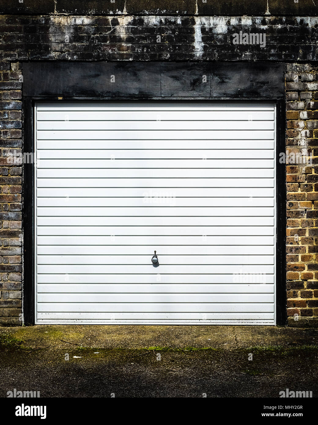 Un singolo garage con un metallo fino e oltre porta in un garage residenziale di blocco Foto Stock