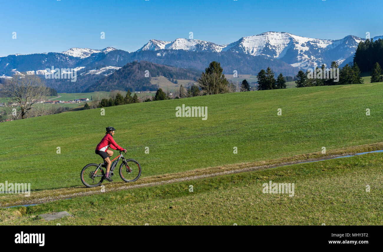 Senior donna mountainbike in primavera nella zona Allgaeu, Tedesco alpes Foto Stock
