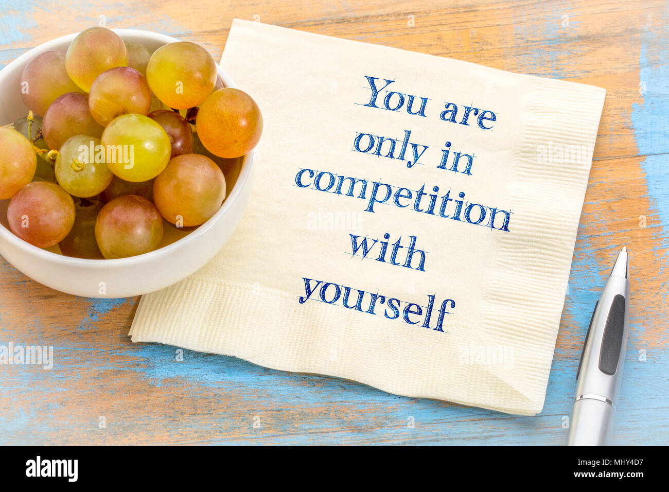 Siete solo in concorrenza con se stessi - scrittura su un tovagliolo con uve fresche Foto Stock
