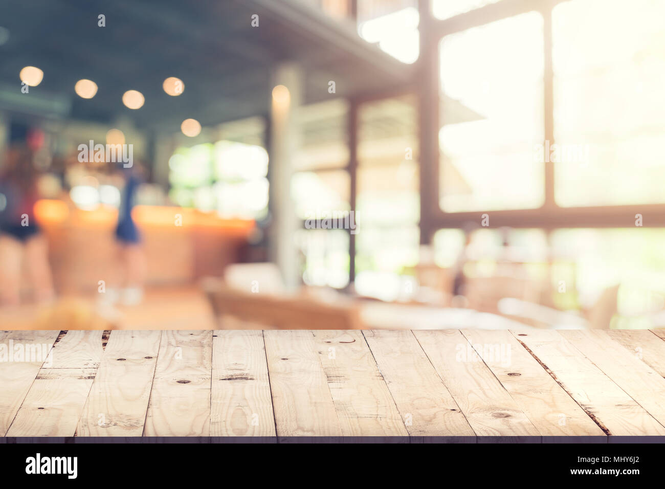 Svuotare tavolo in legno e sfondo sfocato : il cliente presso la caffetteria la sfocatura dello sfondo con bokeh, Vintage tonica. Foto Stock