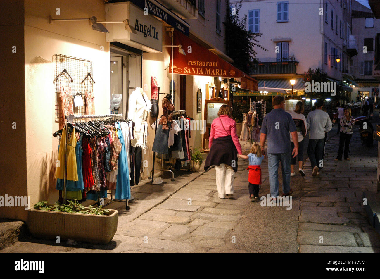 I turisti alla ricerca di una scheda rack oat un negozio di articoli da regalo in una via stretta, Rue Georges Clemenceau nella città vecchia, Calvi in Corsica, isola francese off la sou Foto Stock