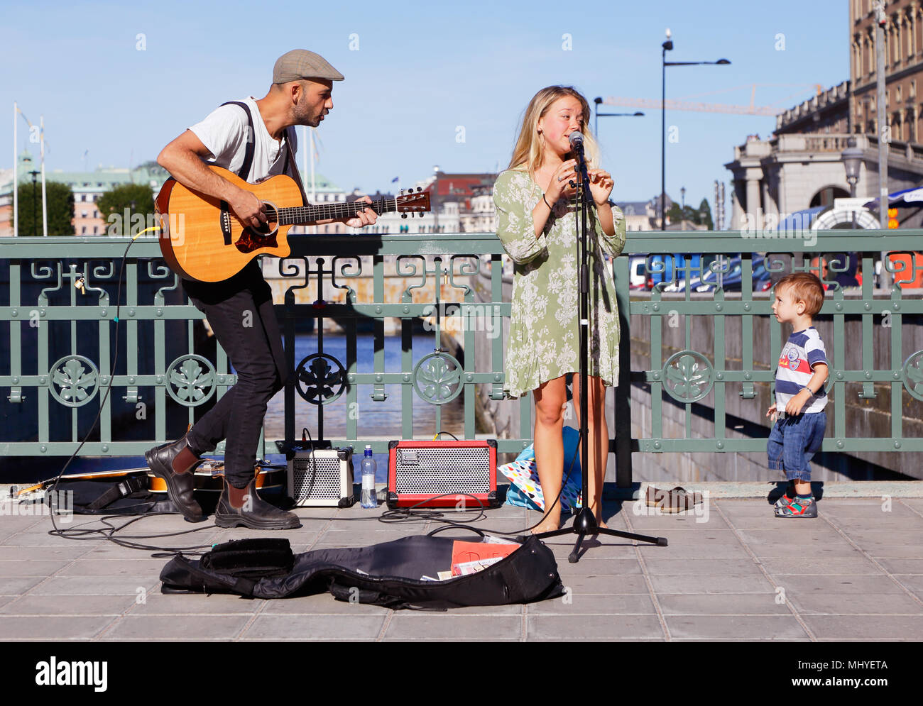 Stoccolma, Svezia - Agosto 19, 2015: due musicisti di strada sul ponte Stallbron a Stoccolma con un interessato little boy dal pubblico. Foto Stock