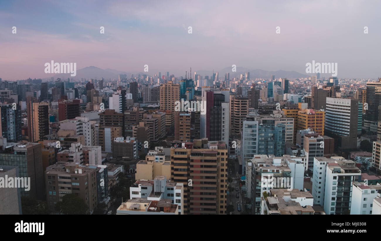 Vista aerea di colorato dello skyline della città di fronte montagne Foto Stock